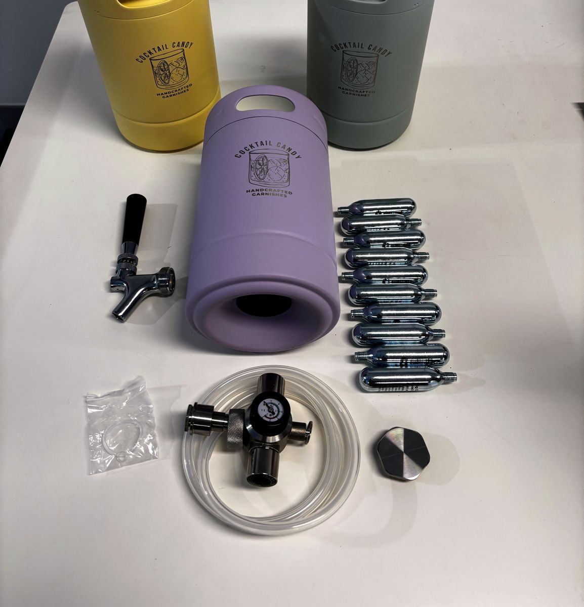 Everything in the box laid out: Violet Hour Purple keg, beer tap, 10 CO2 bulbs, regulator with flexi tube, spare O-rings and travel lid