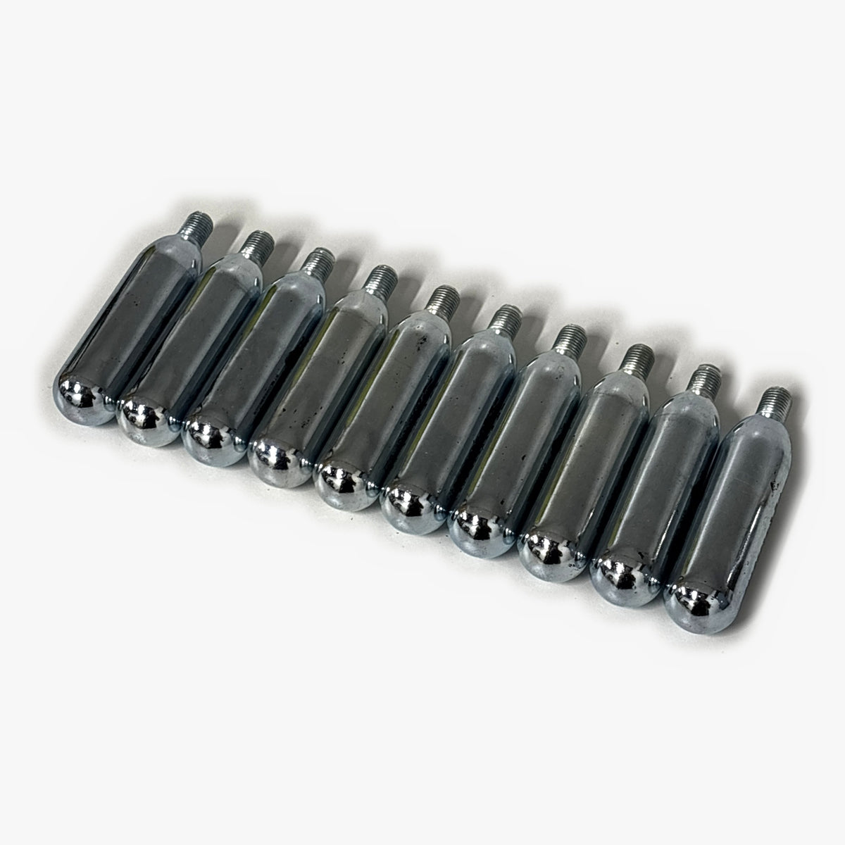 Ten 16g threaded CO2 bulbs lined up at an angle, the refill pack for the Cocktail Candy Mini Keg
